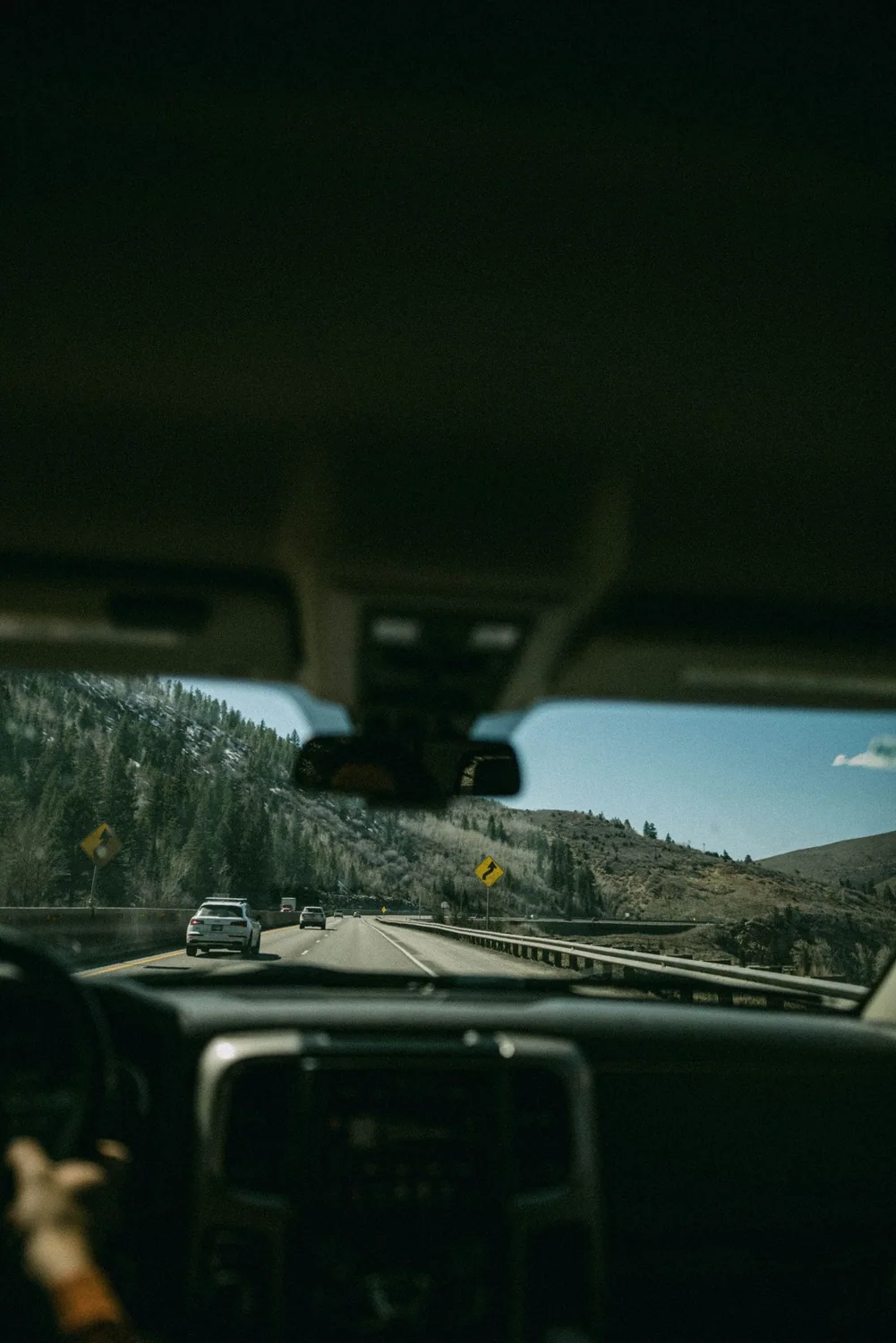 Driver view through the windshield of the road and traffic that windshield-mounted ADAS cameras monitor
